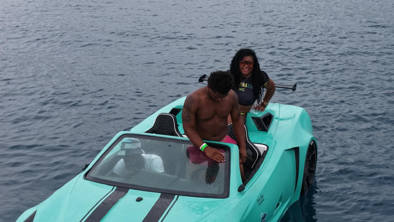Guests boarding a turquoise Jet Car on the water